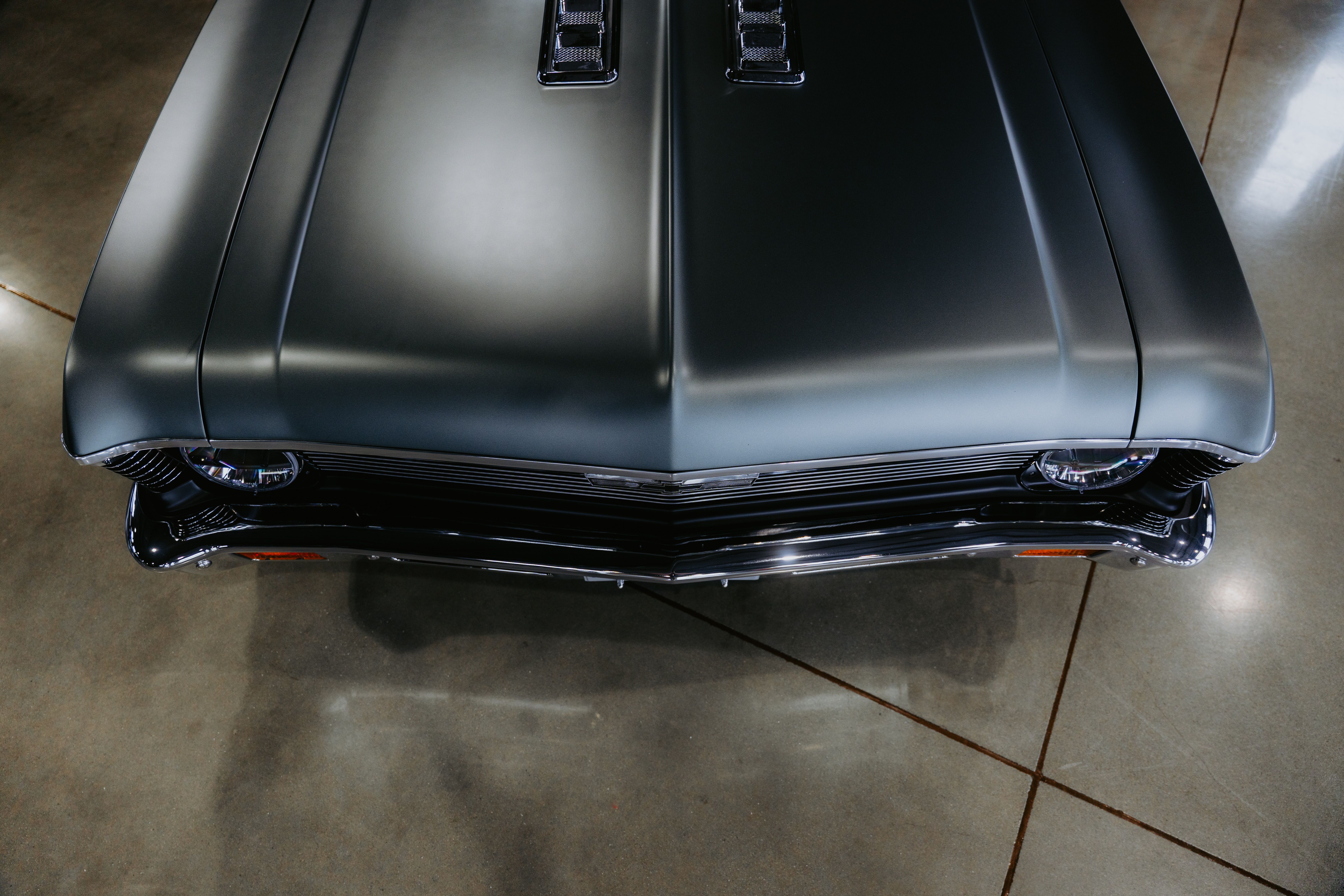 Top view of a classic muscle car with sleek design in a garage setting.
