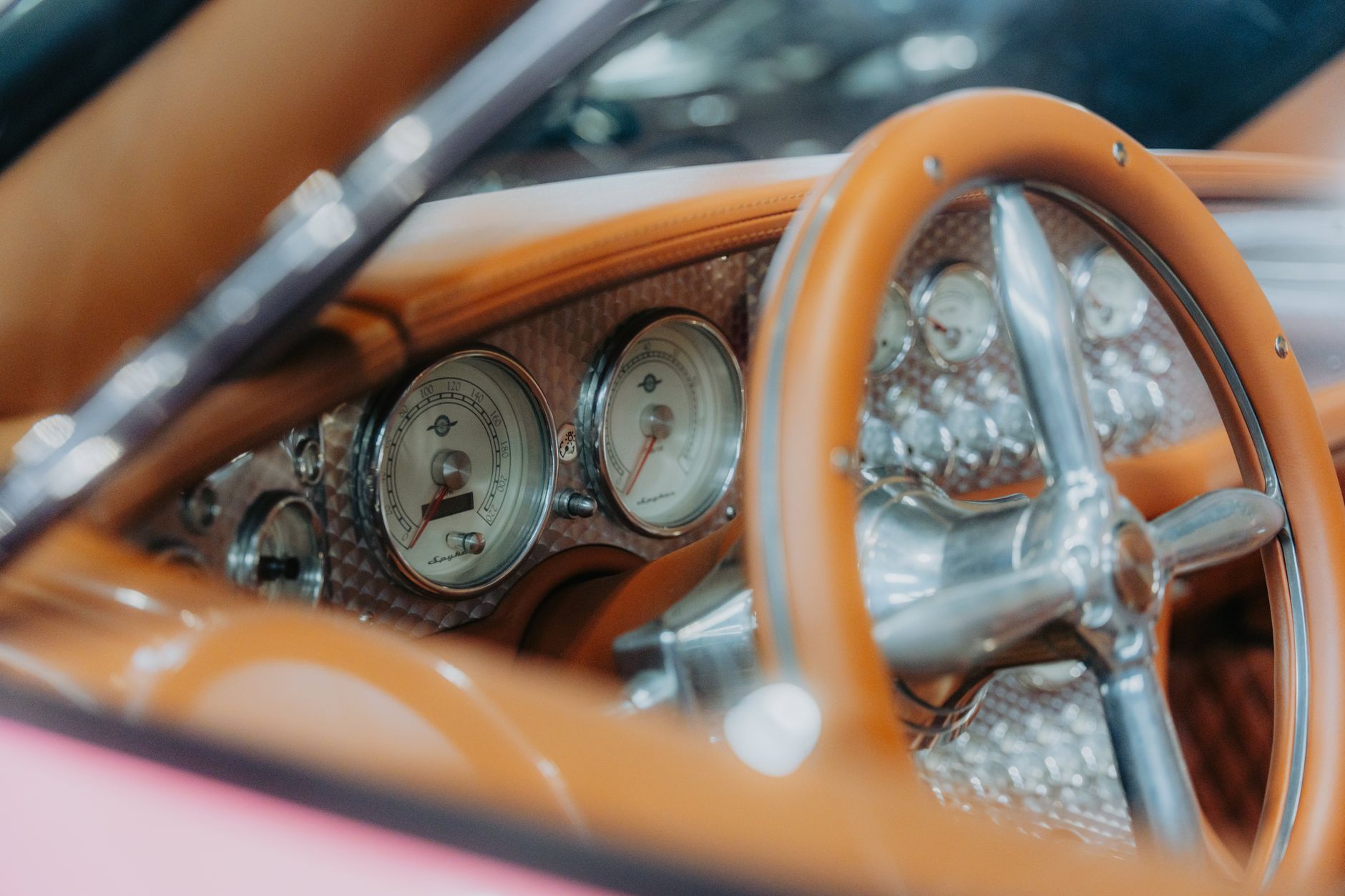 Close-up dari setir mobil vintage dan dasbor dengan desain retro klasik dan instrumen.