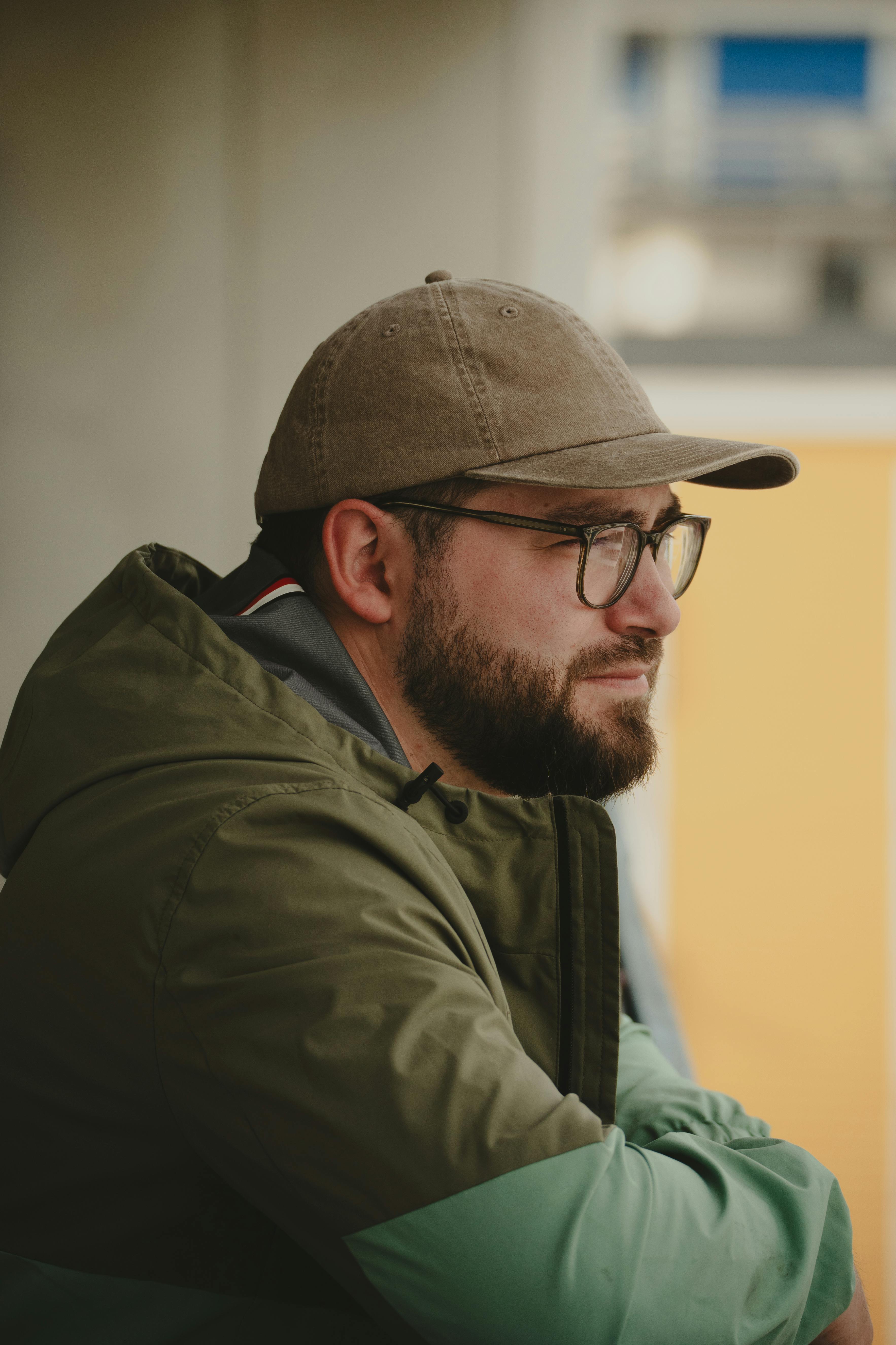 Gratuit Bărbat cu barbă, purtând șapcă și ochelari, în Nuuk, Groenlanda. Portret în aer liber, cu o dispoziție contemplativă. Fotografie de stoc