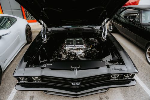 Free Close-up view of a classic Chevrolet Chevelle showcasing its powerful engine in a parking lot. Stock Photo