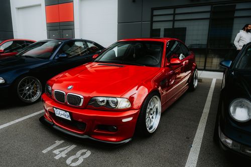Free Red sports car parked in an urban area with other vehicles. Modern automotive design. Stock Photo