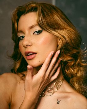 Close-up portrait of a woman posing gracefully, adorned with a stylish necklace, showcasing elegance and beauty.