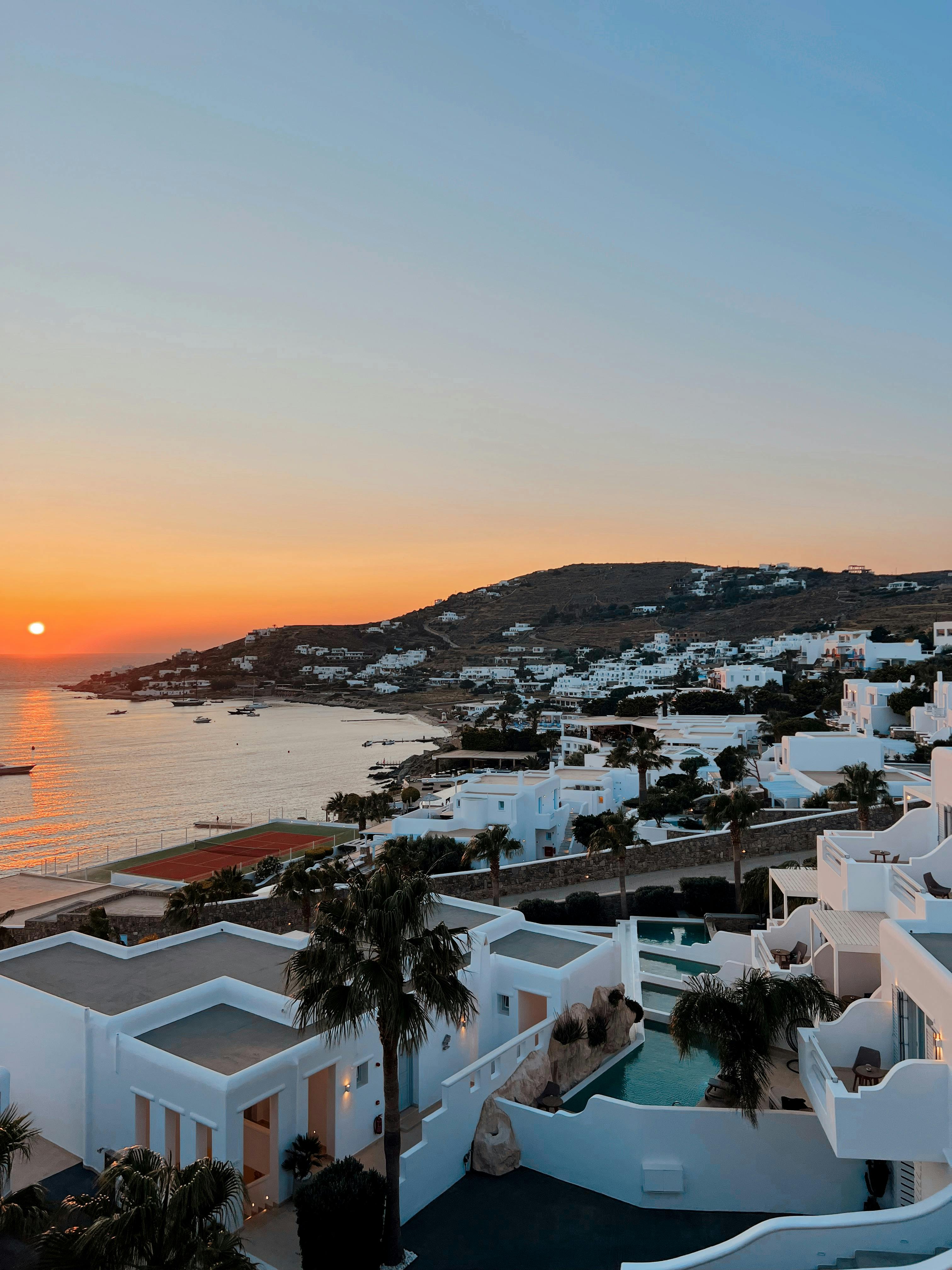 Mykonos sunset over white buildings and the sea