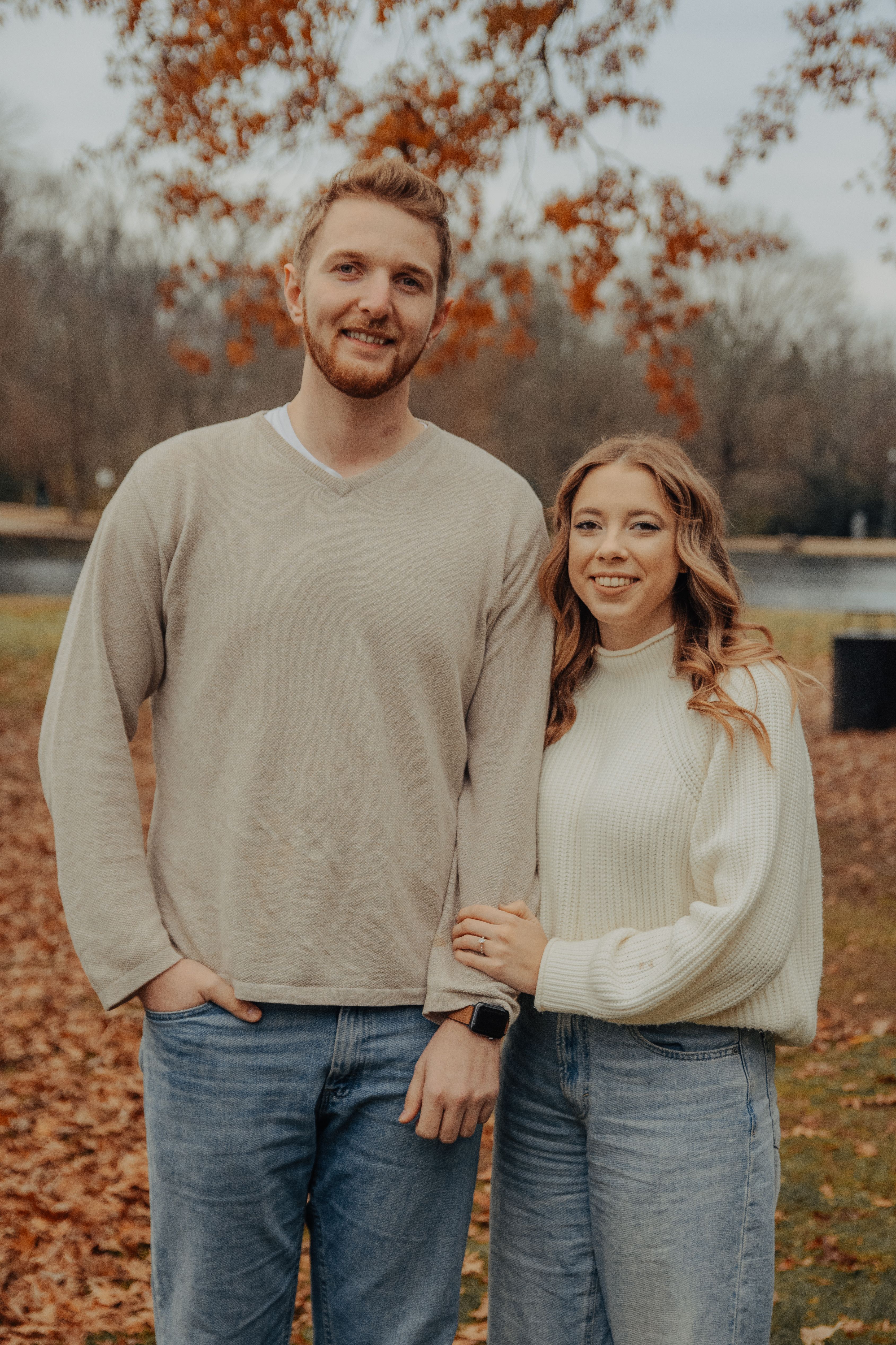 Warm and natural couples portrait during autumn in a picturesque park.