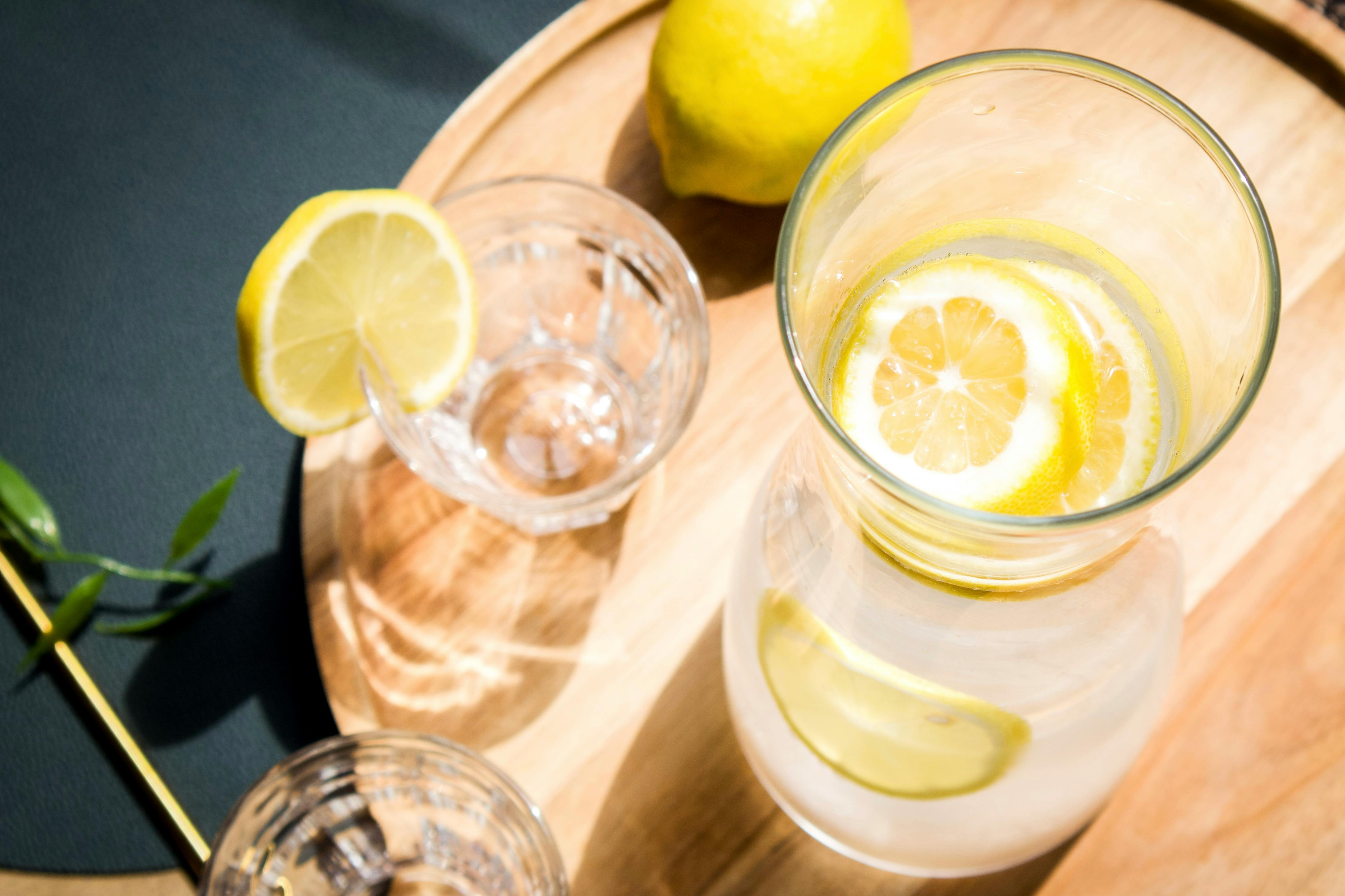 Warm Lemon Water In A Glass On A Wooden Table With Fresh Lemons And A Cozy Morning Setting