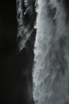 Dynamic waterfall on an island captured with moody tones, showcasing nature's power.