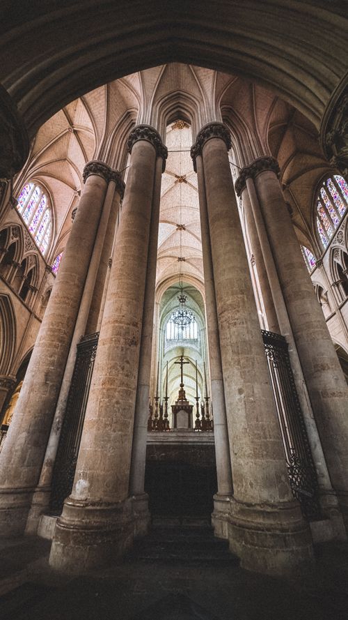 Free Discover the stunning gothic architecture of this cathedral interior with towering columns and vaulted ceilings. Stock Photo