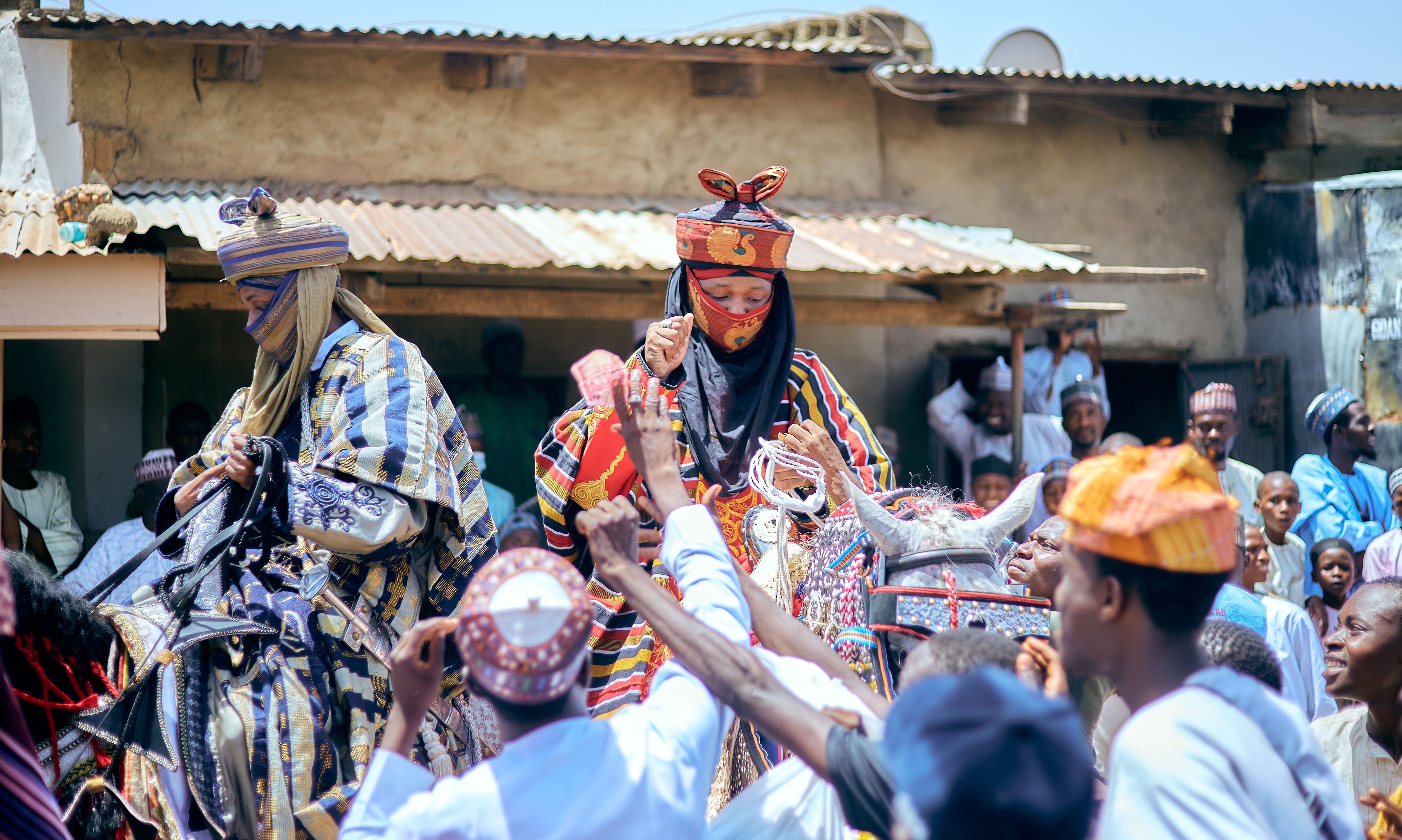 Vibrant street parade showcasing traditional African attire and festive atmosphere.