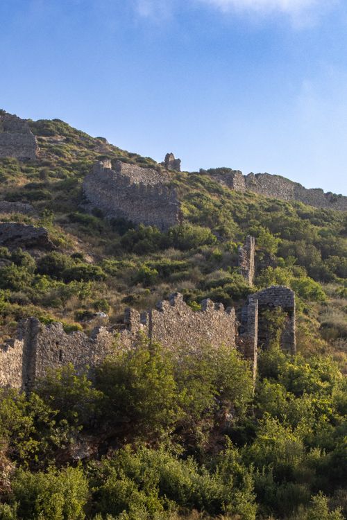 Free Scenic view of ancient stone ruins on a lush hillside at sunrise. Stock Photo