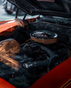 Close-up of an antique car engine with open hood, showcasing vintage mechanical details.
