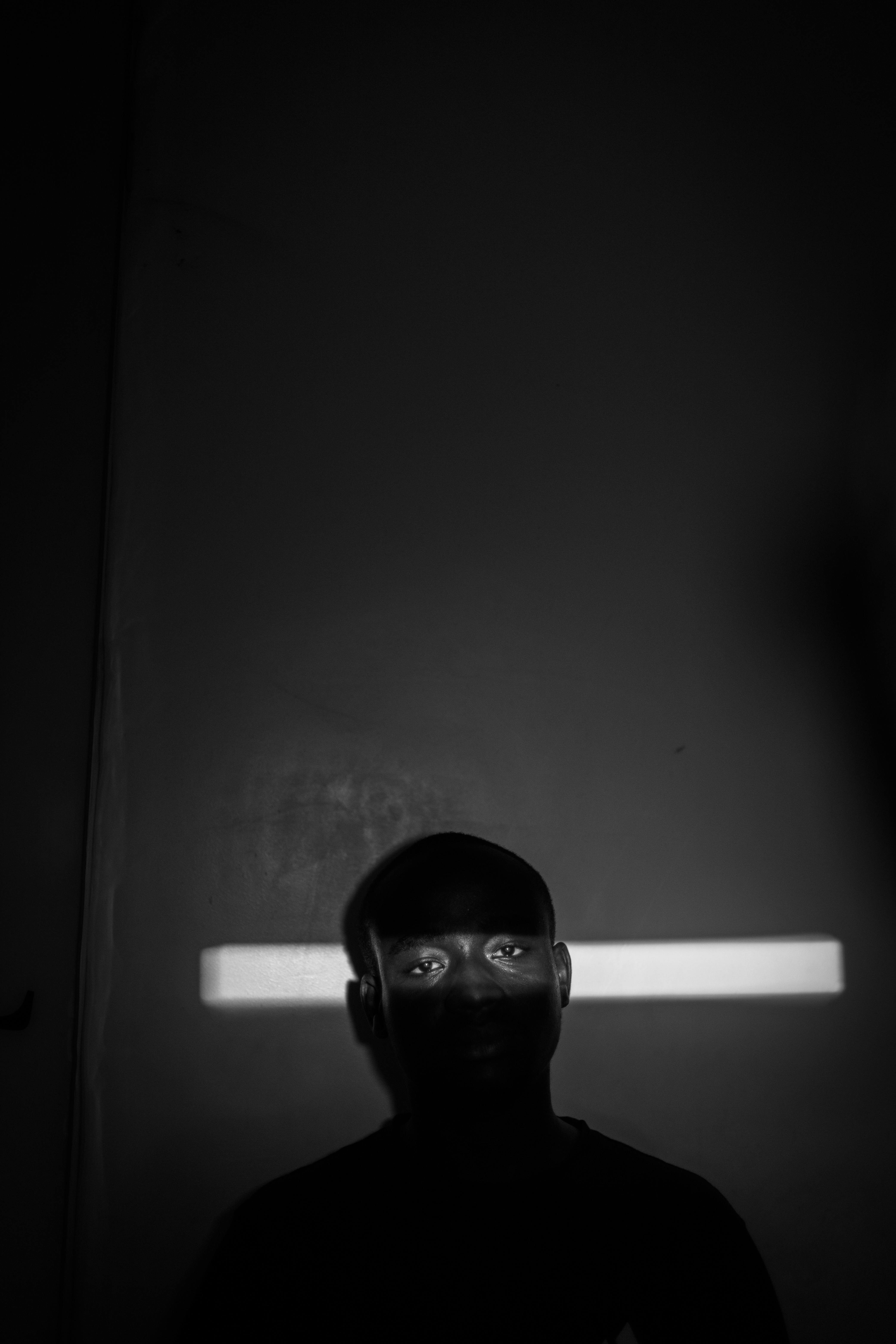 De franc Retrat en blanc i negre amb un feix de llum espectacular que ressalta els ulls per a un efecte misteriós. Foto d'estoc