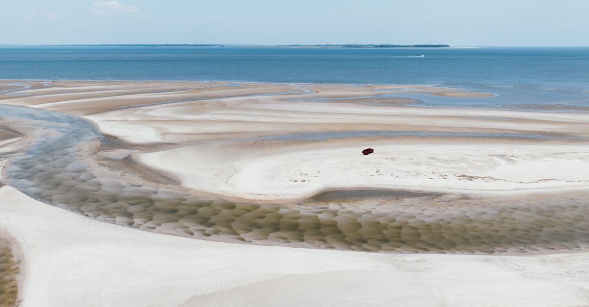 Stunning aerial shot of the sandy beach and ocean at Hilton Head Island, showcasing intricate patterns and serene beauty.