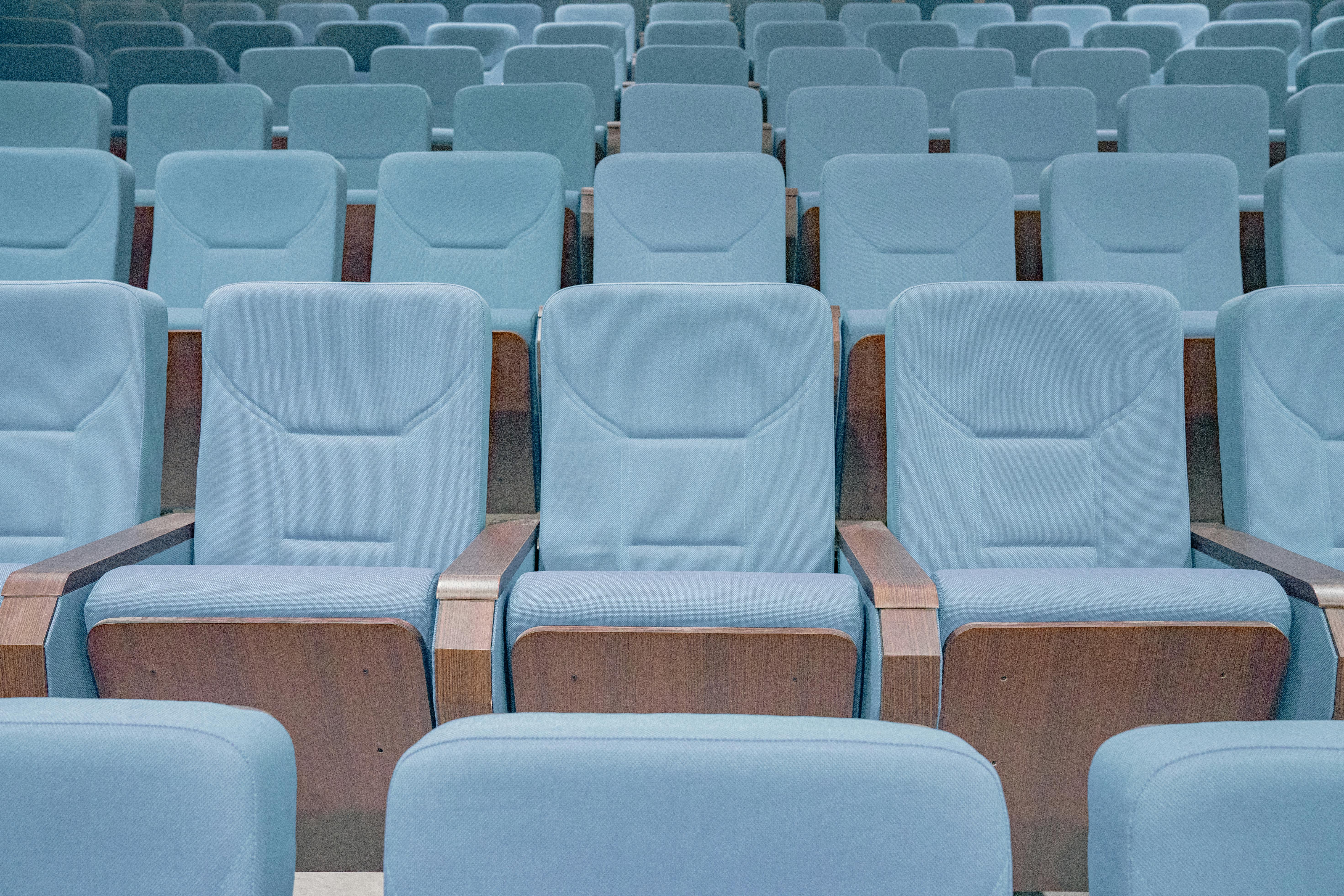 Kostenlos Reihen moderner blauer Theatersitze in einem leeren Auditorium, die das architektonische Design hervorheben. Stock-Foto