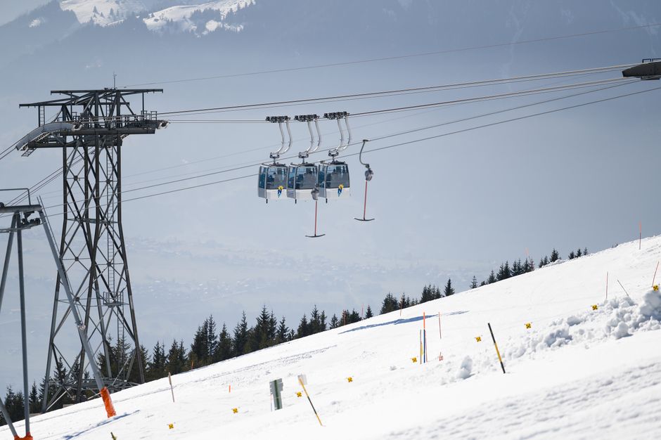Scenic view of ski lift cable cars over snowy slopes in the Swiss Alps during winter.