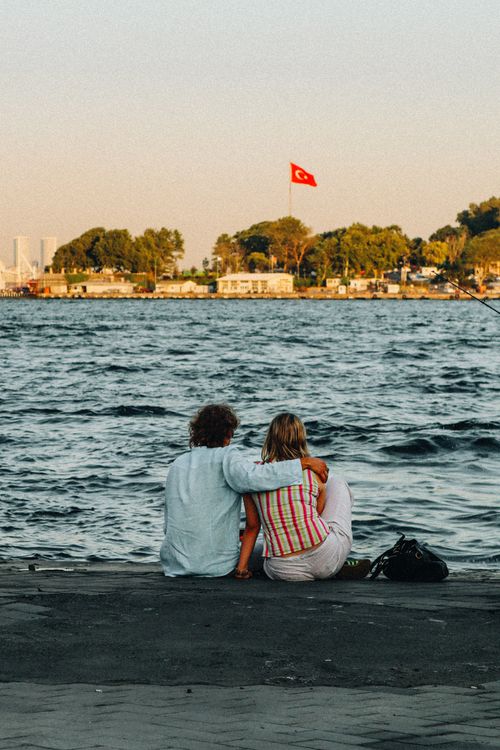 Free Romantic couple enjoying the Bosphorus view in Istanbul with Turkish flag. Stock Photo