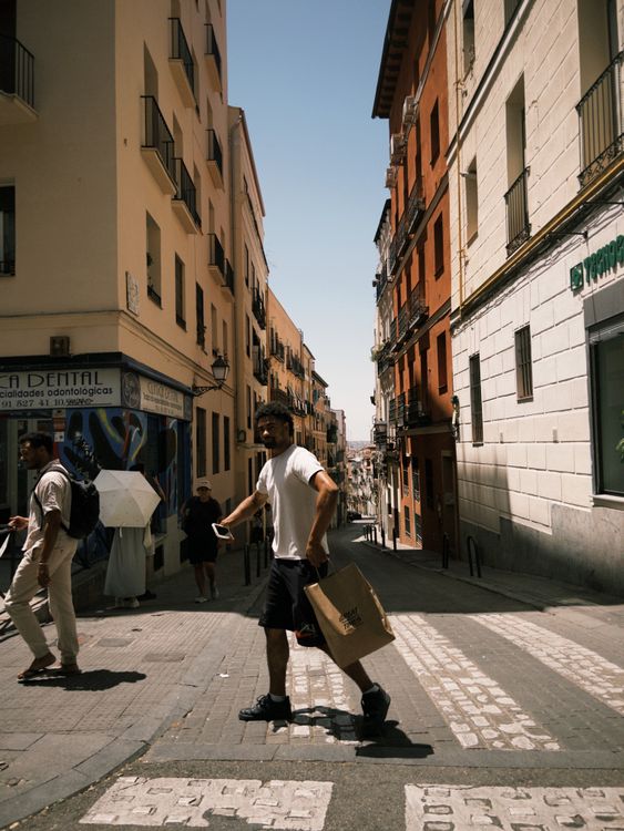 People Walking in Sunlit European City Street · Free Stock Photo