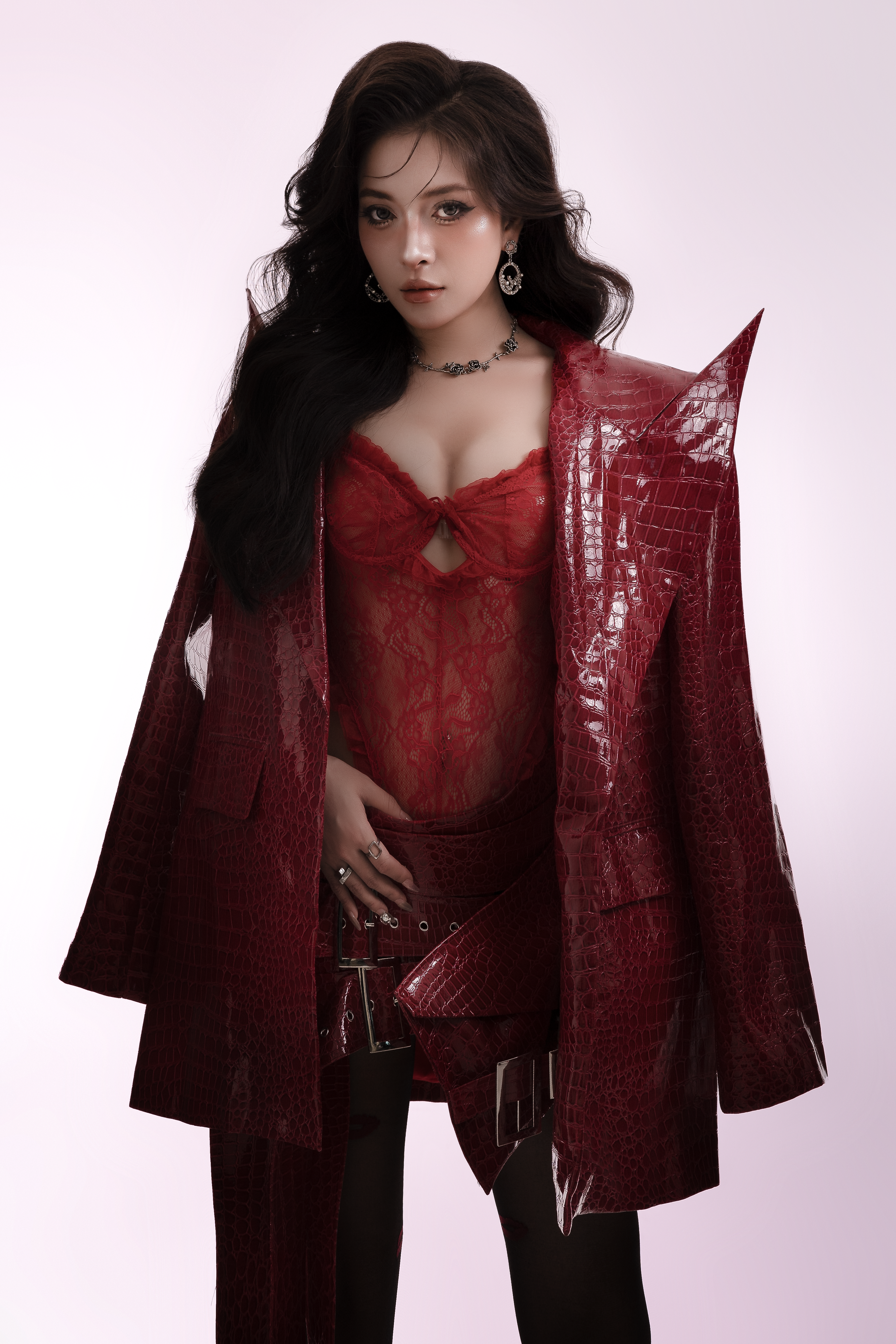 Fashionable woman posing in a striking red outfit with a glossy textured jacket.