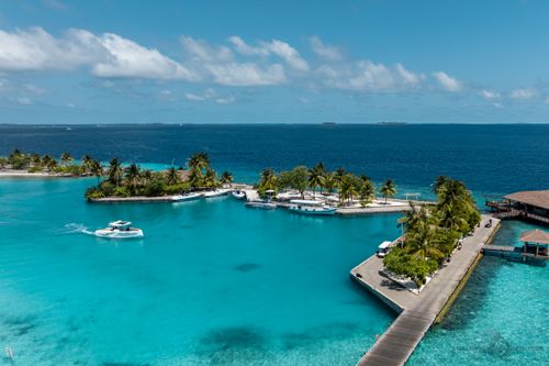 Free Captivating aerial view of a luxurious island resort in the Maldives showcasing turquoise waters and palm trees. Stock Photo