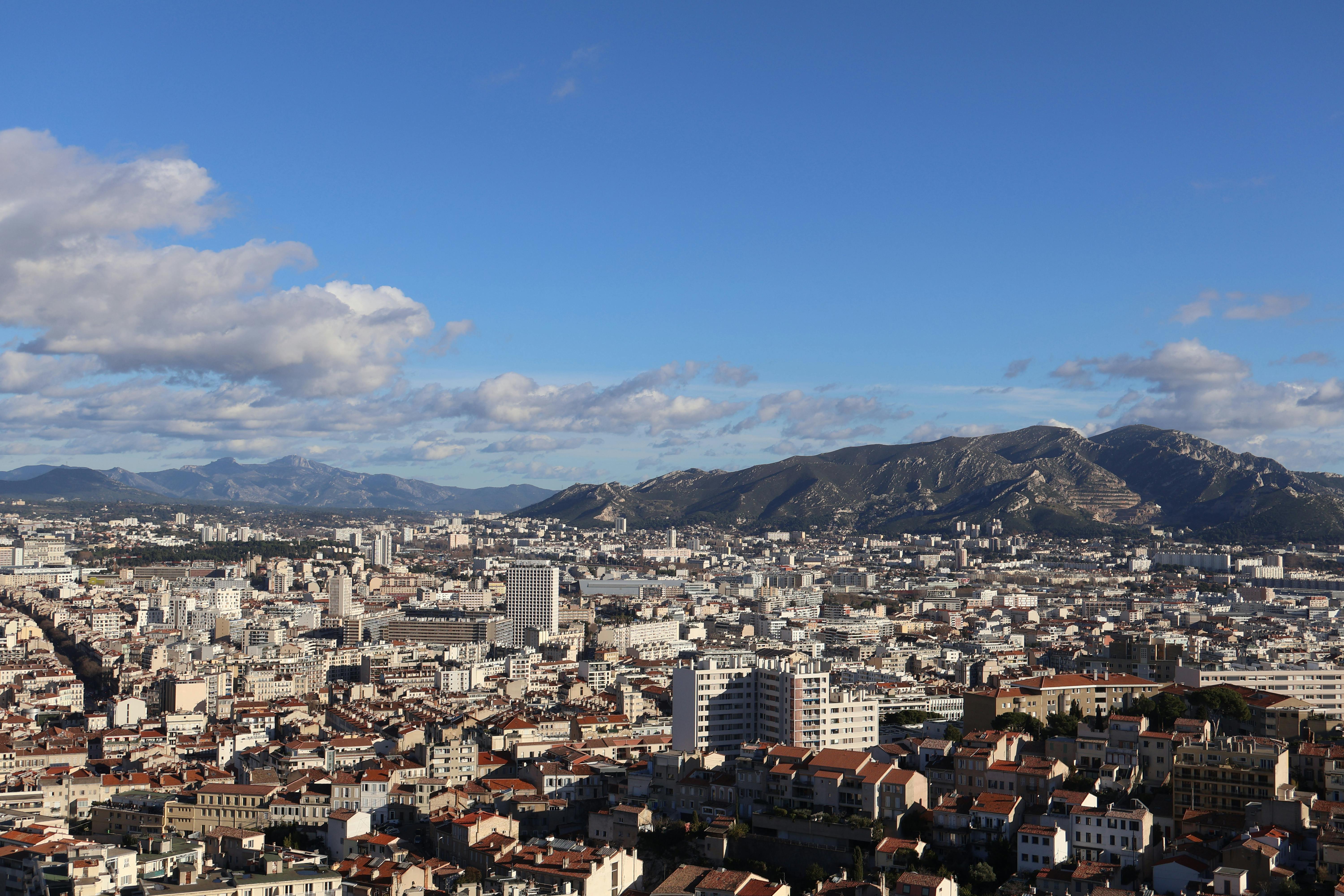 A stunning aerial view of the cityscape of Marseille, France, under a bright summer sky.