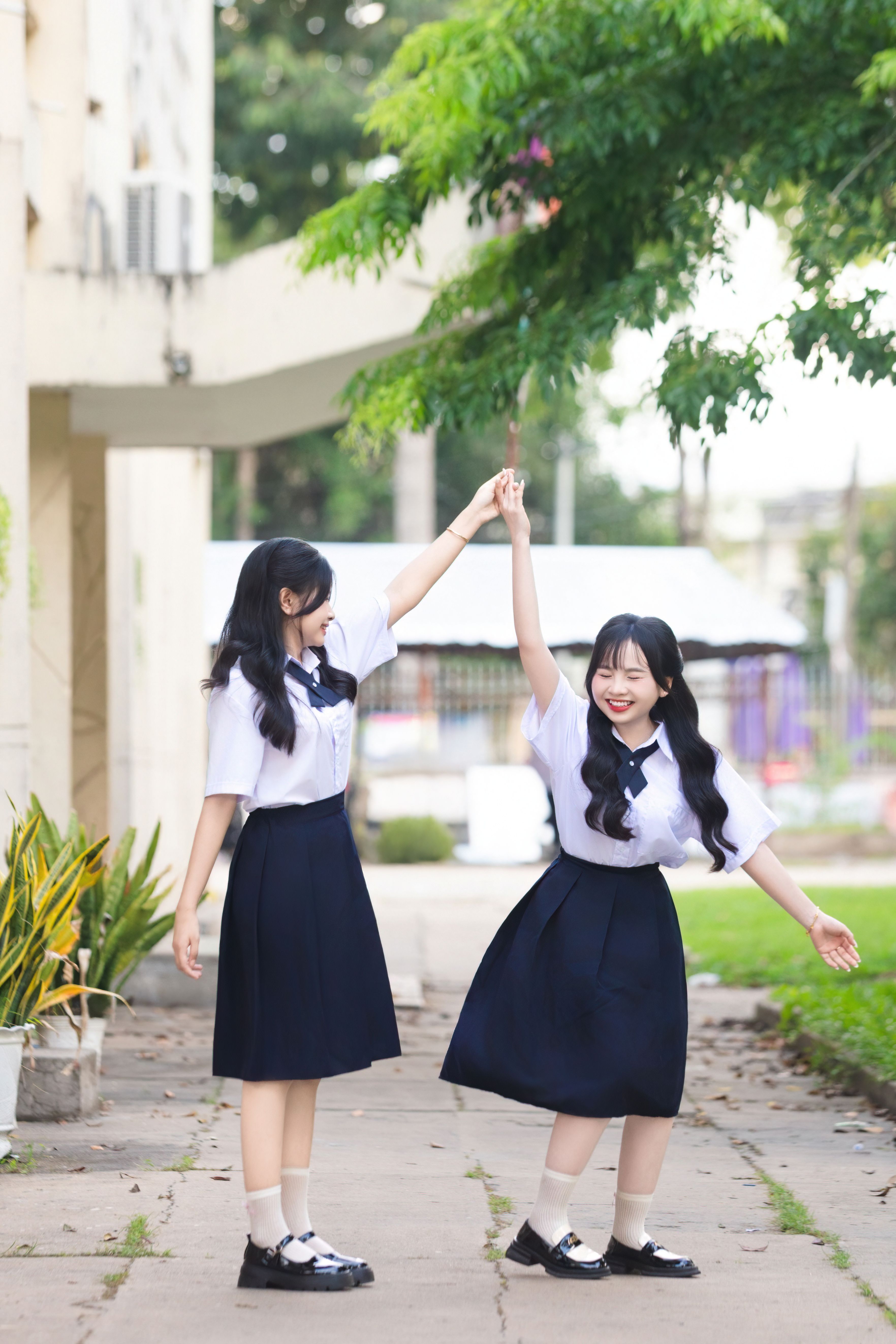Cheerful Schoolgirls Dancing Outdoors in Uniforms · Free Stock Photo