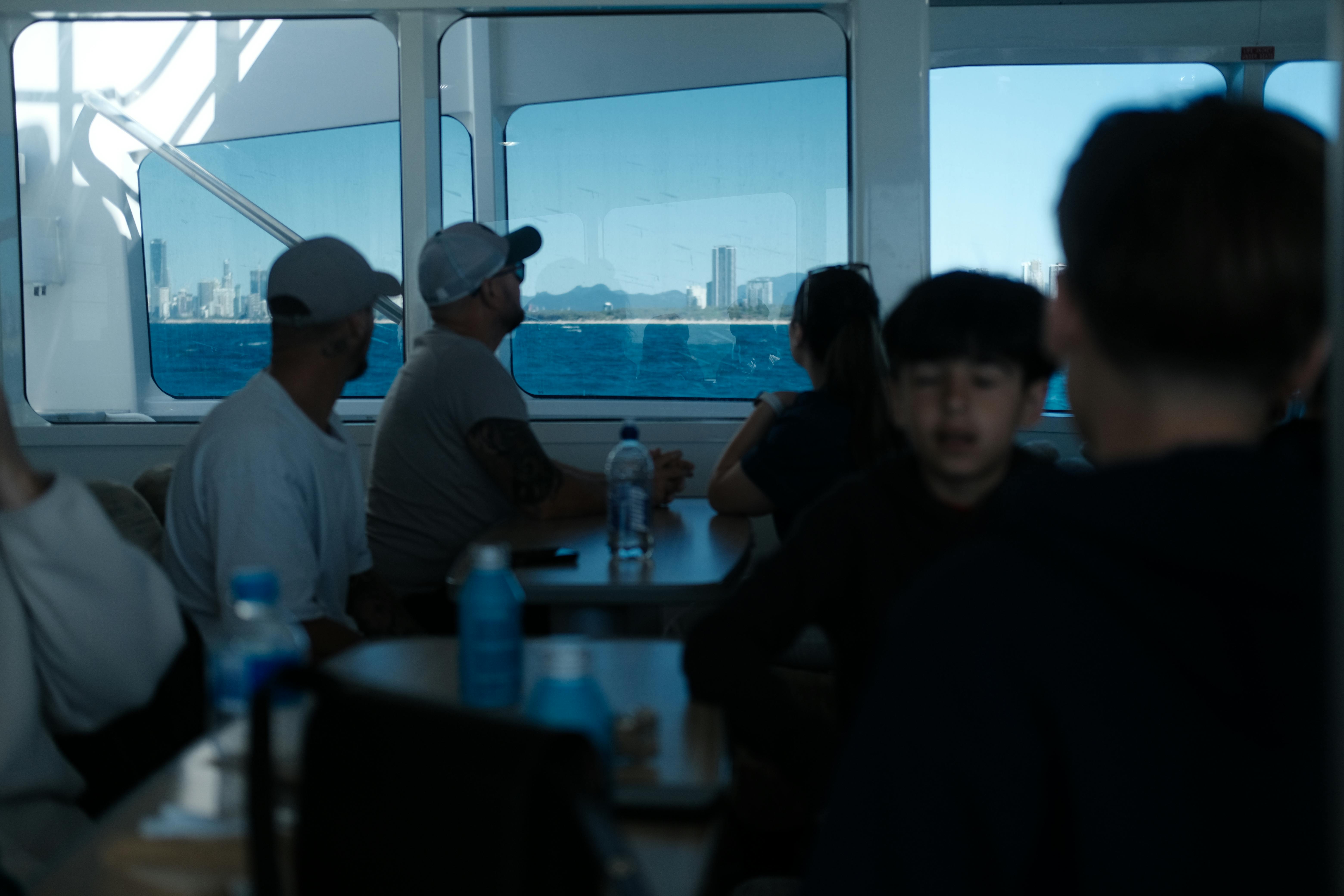 grátis Passageiros em uma balsa apreciando a vista da cidade através das janelas. Foto profissional