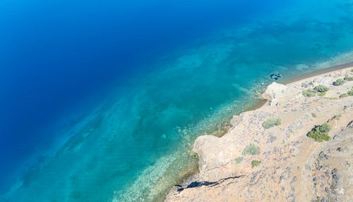 Free Stunning aerial view of rocky shoreline with clear turquoise waters in Greece. Stock Photo