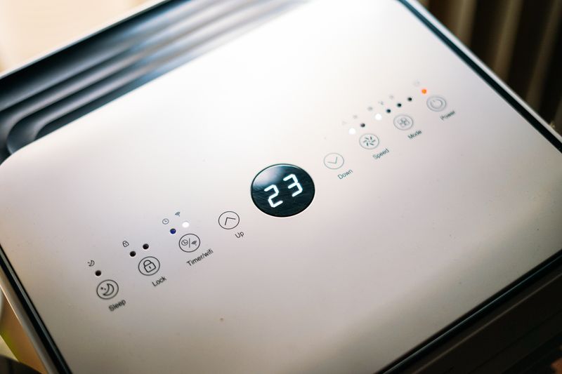 Close-up of a sleek air conditioner control panel displaying temperature