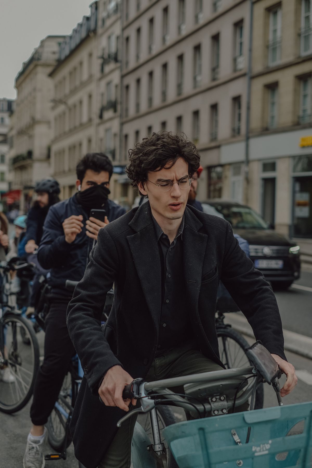 Urban cyclists riding through city traffic with helmets and cycling equipment