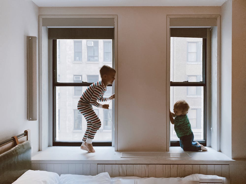 Free Two Kids Playing Beside Glass Windows Stock Photo