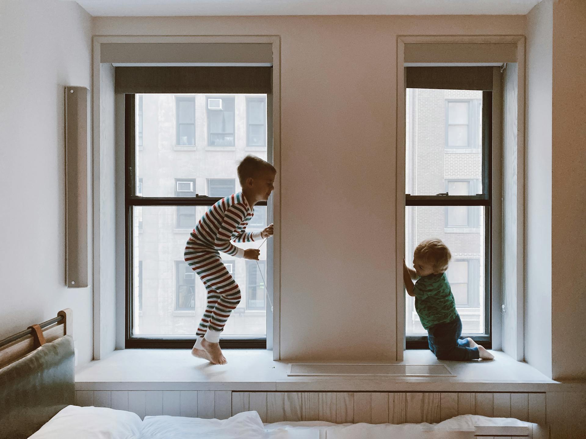 Two Kids Playing Beside Glass Windows