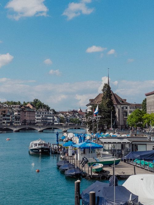 Free Beautiful summer day on Limmat River with boats and old town Zurich skyline. Stock Photo