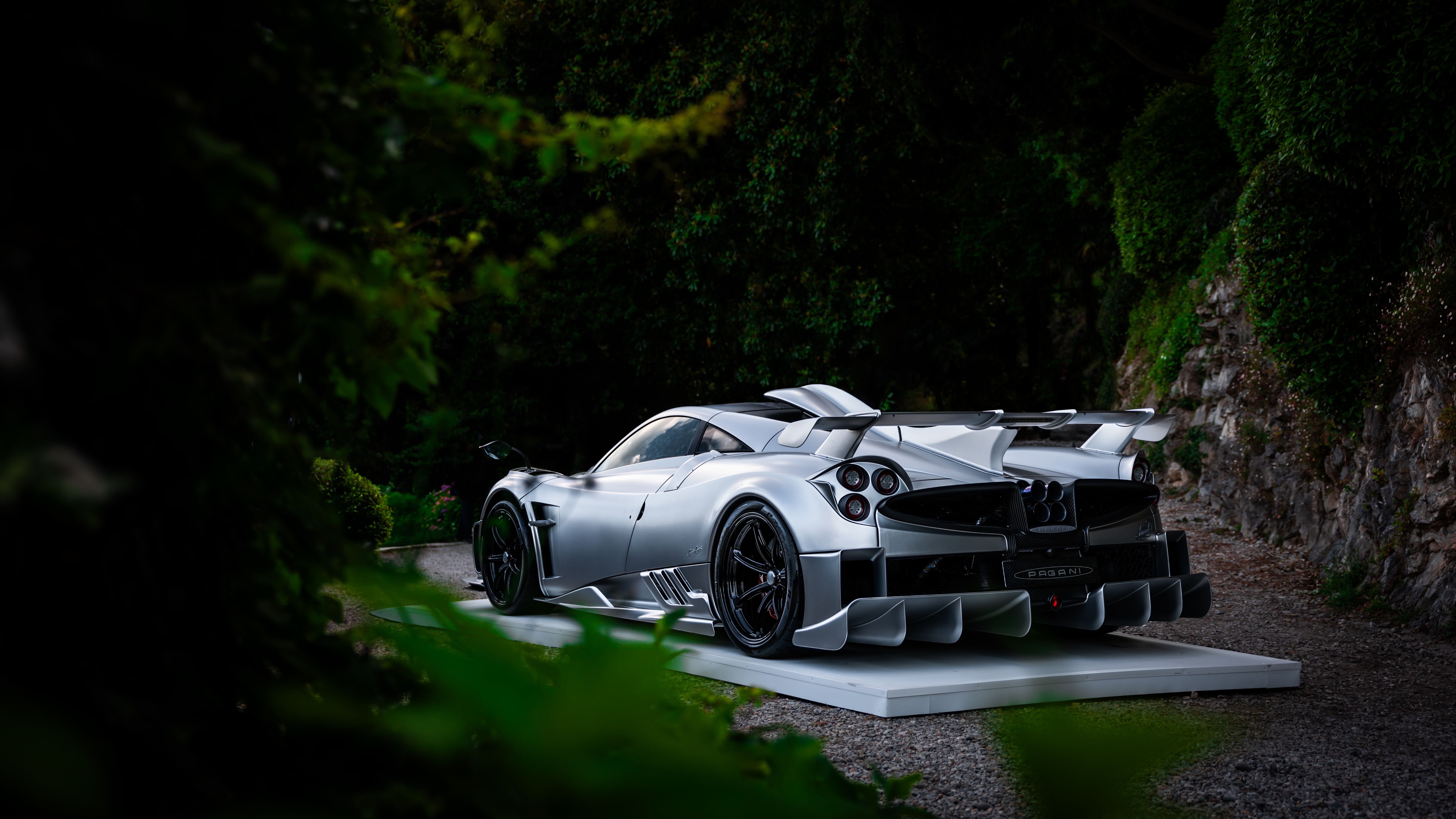 Silver hypercar parked beneath city lights at night