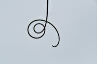 Minimalist Spiral Tendril Against Sky Background