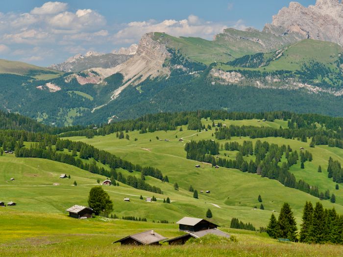 Alpine cabins scattered across the Alpe di Siusi plateau — photo by Dirk Pothen on Pexels