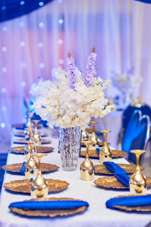 Free Luxurious wedding table setting with blue and gold theme, featuring floral centerpiece. Stock Photo