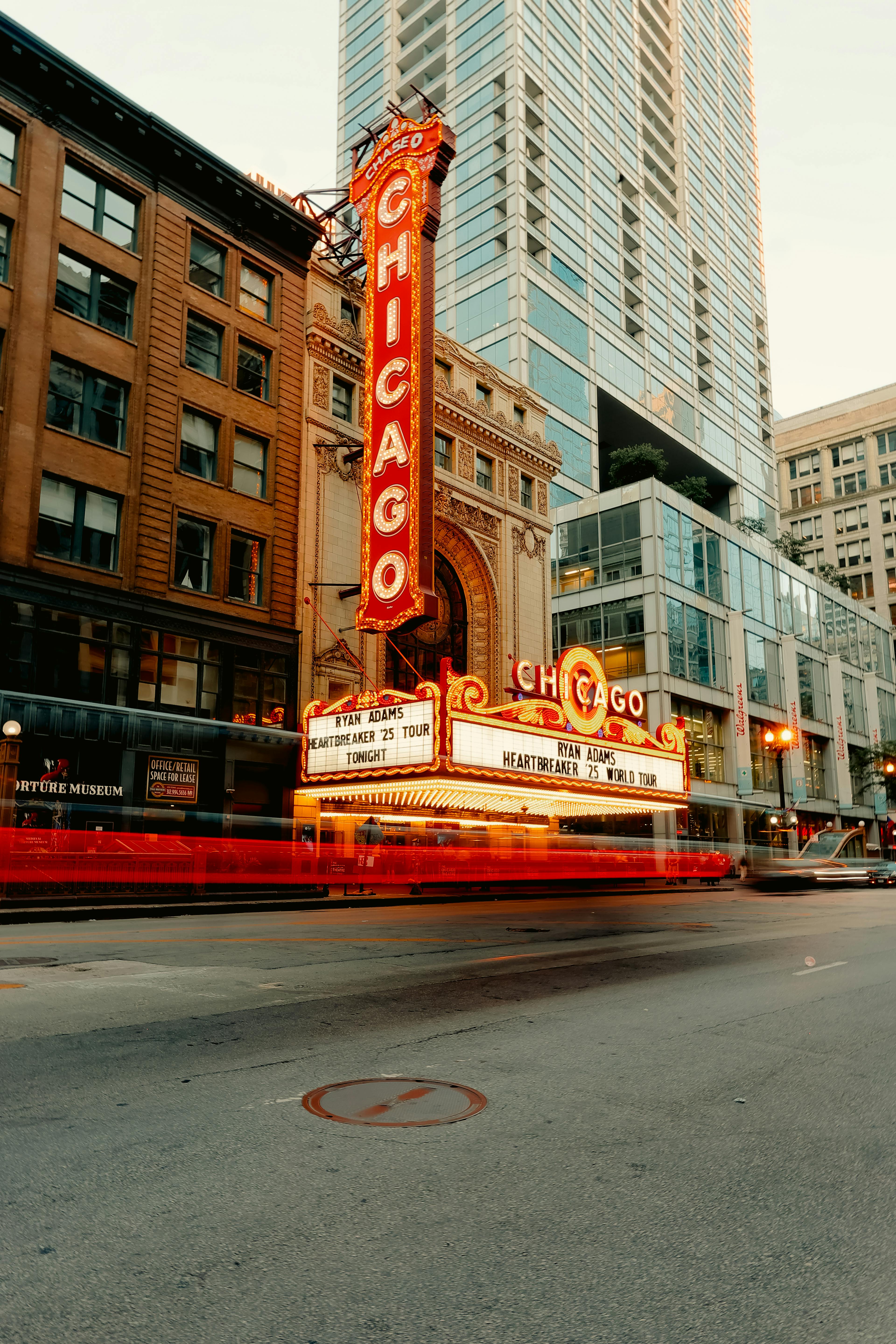 Gratis Nattutsikt over Chicago Theater med lysløyper på en travel gate. Arkivbilde