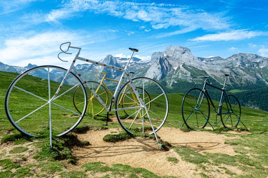 Vibrant bicycle sculptures set against a stunning mountainous backdrop under a clear sky.