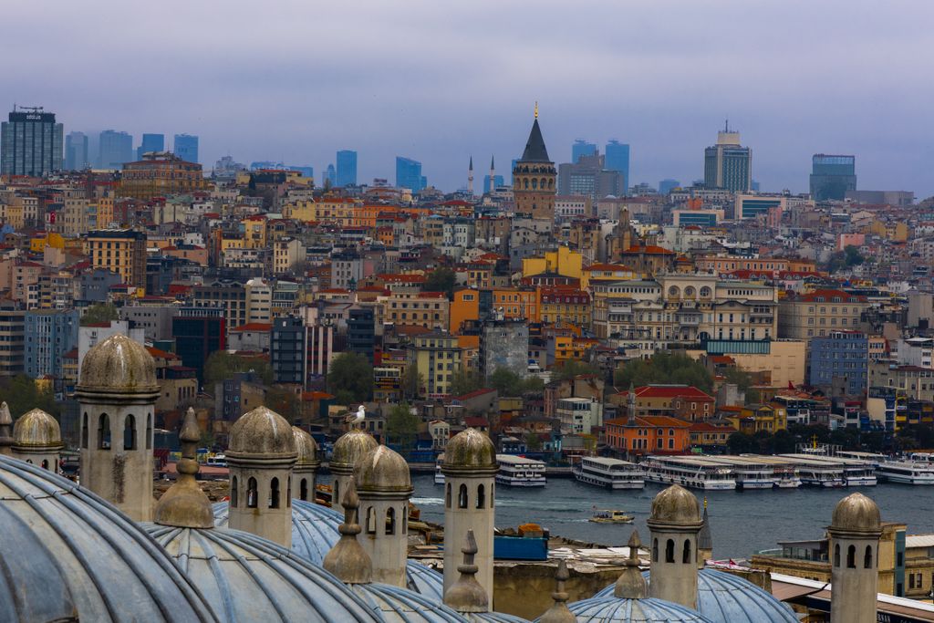 Mosque domes in the foreground, with Istanbul's rooftops, the water and Galata Tower behind