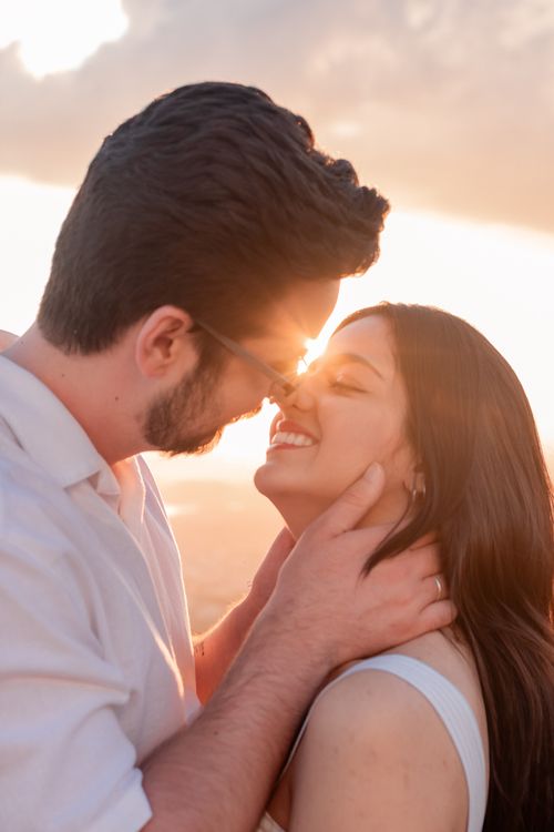 Free A loving couple shares an intimate moment outdoors during a vibrant sunset. Stock Photo