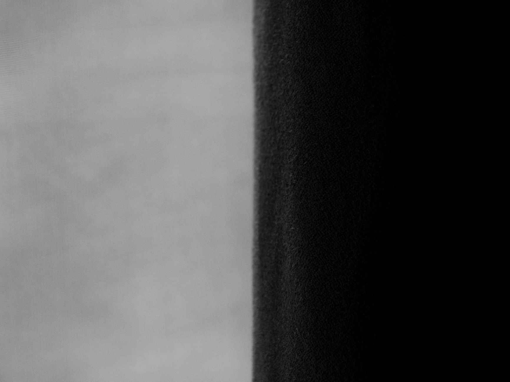 極簡風窗簾怎麼選?避開廉價感布料顏色尺寸全攻略 Close-up of contrasting greyscale drapes in a modern interior setting.