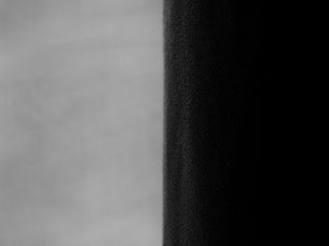 Close-up of contrasting greyscale drapes in a modern interior setting.