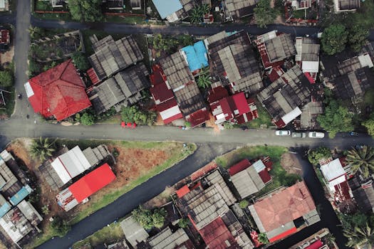 Aerial shot capturing a colorful urban neighborhood with distinctive red and blue roofs.
