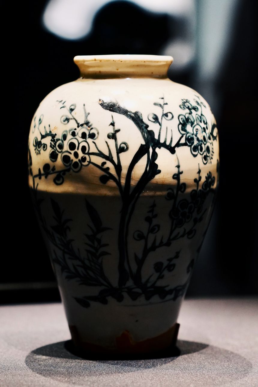 Glazed painted jar lit on a gallery plinth — photo by pp zhu on Pexels
