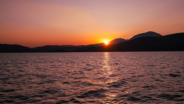 A tranquil sunset over the sea in Greece with vibrant colors and soft waves. Perfect for nature lovers.
