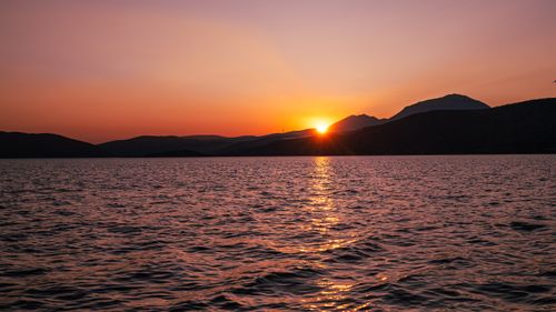 Free A tranquil sunset over the sea in Greece with vibrant colors and soft waves. Perfect for nature lovers. Stock Photo