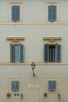 Classic European building facade featuring blue shutters and detailed stonework.