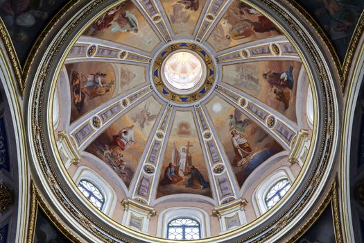 Intricate dome with religious frescoes and windows at a church in Vigevano, Italy.
