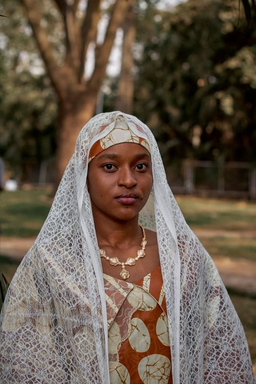 Free Elegant woman in traditional African clothing outdoors, wearing a lace veil. Stock Photo