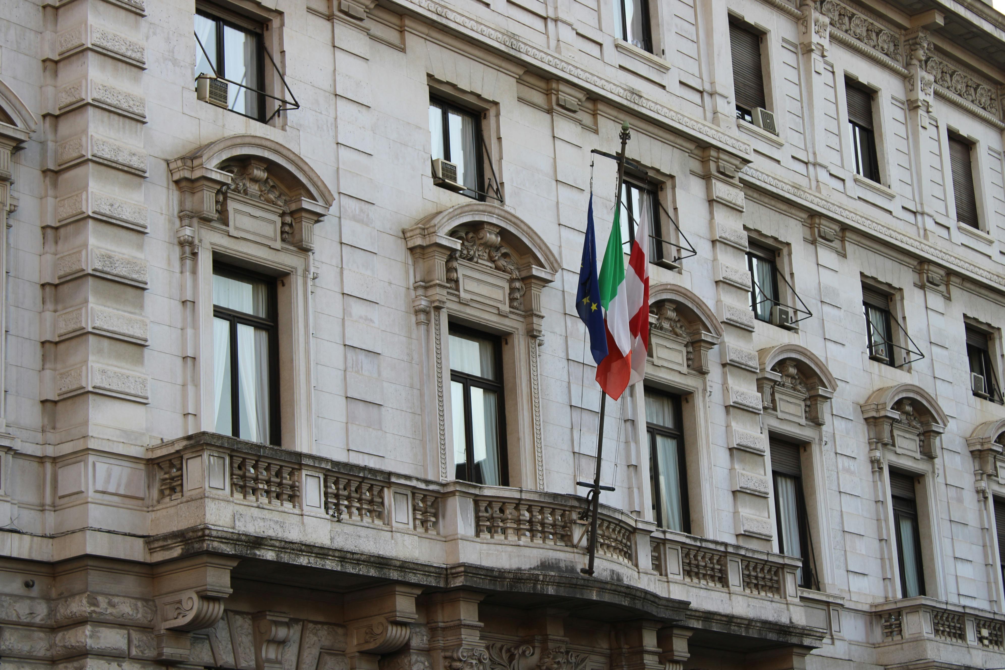 Elegant Renaissance architecture in Milan, featuring Italian and EU flags. - Milán