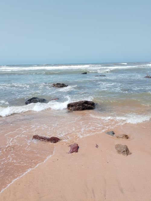Free Relaxing view of a sandy beach with gentle waves and rocks in Casablanca, perfect for serene escapes. Stock Photo